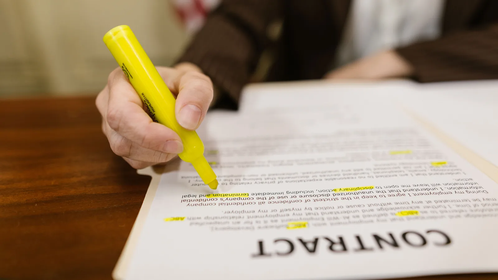 A hand marking a clause on a printed contract, the paperwork a director loan needs