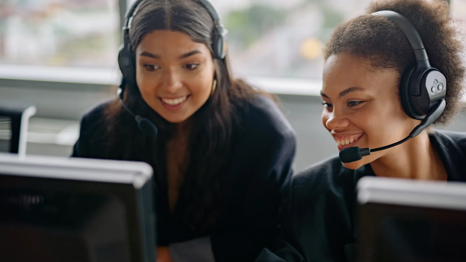 Two agents at work on an operations floor, headsets on