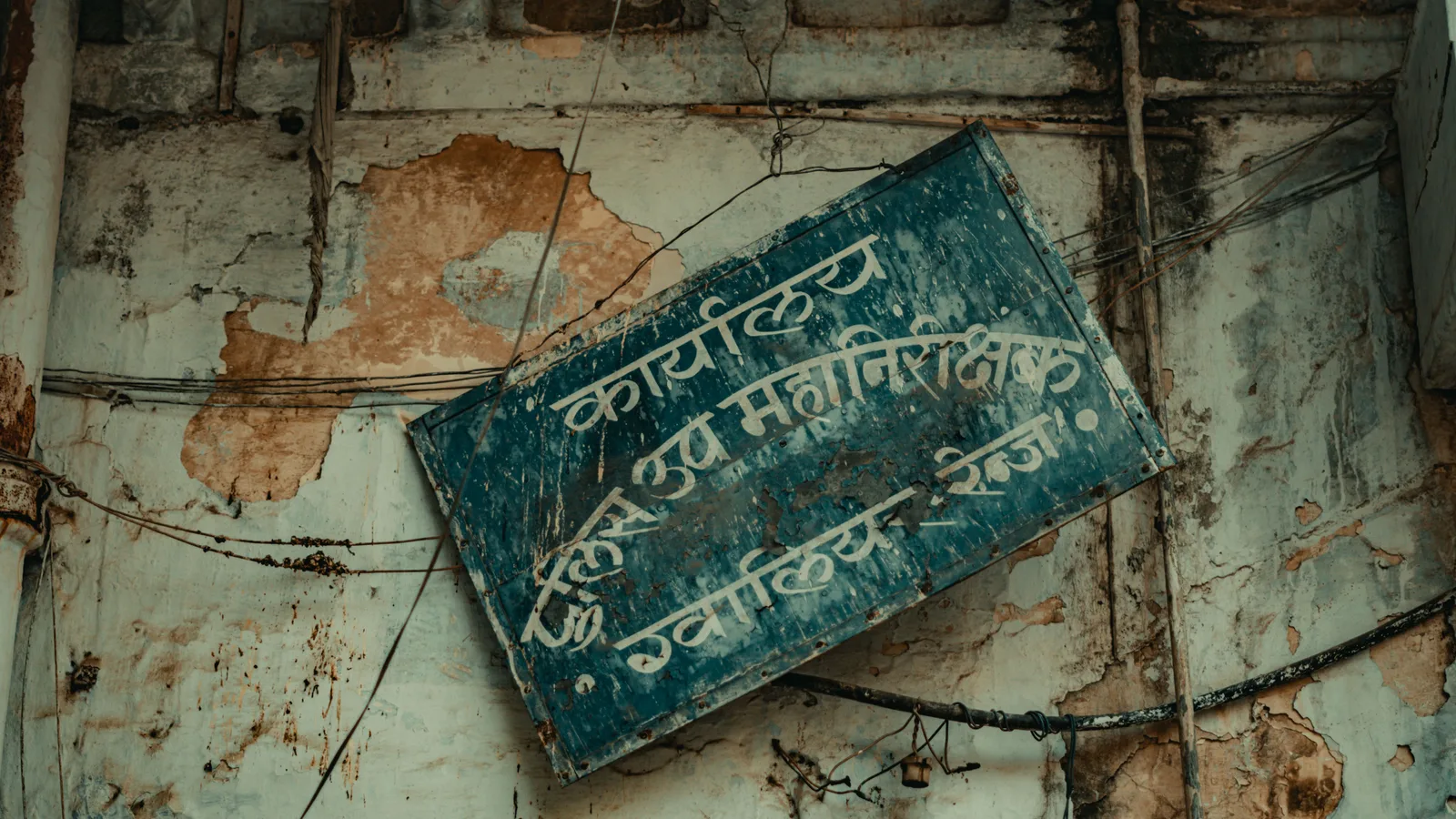 A framed statement on an office wall above an ordinary working corridor
